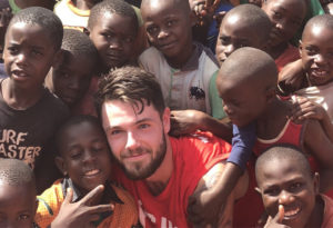 Student on a mission trip in Zambia surrounded by local children