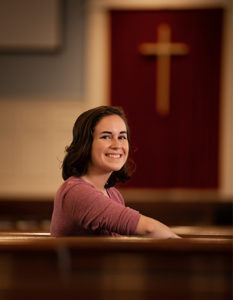 Student sitting in a chapel pew