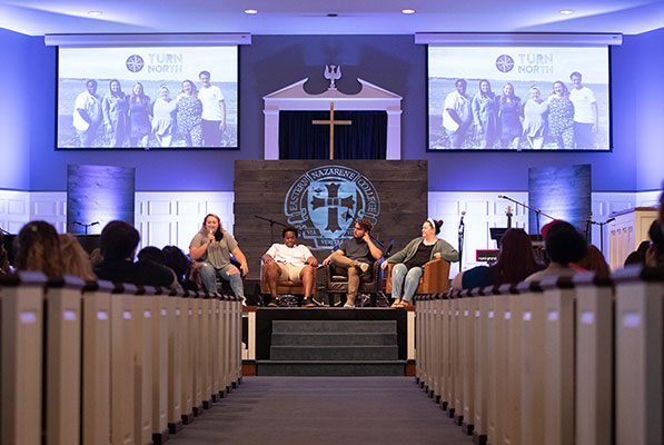 Students in chapel participating in a panel 