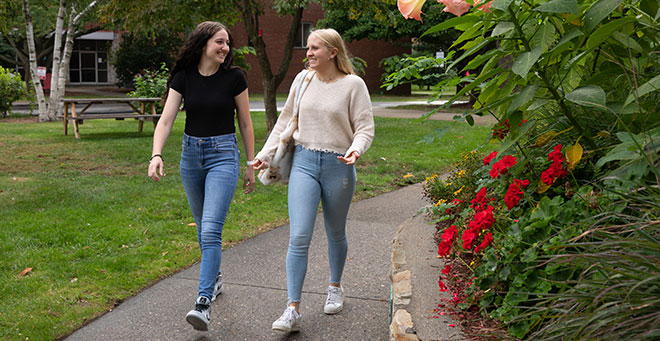 Two female students walking through campus 