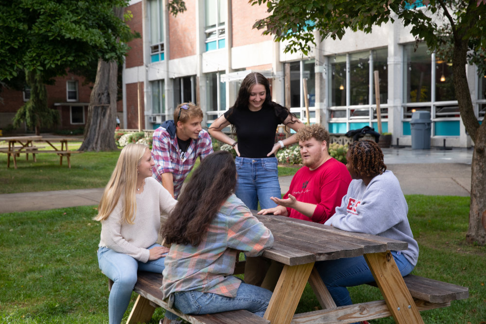 Students interacting around a picnic table